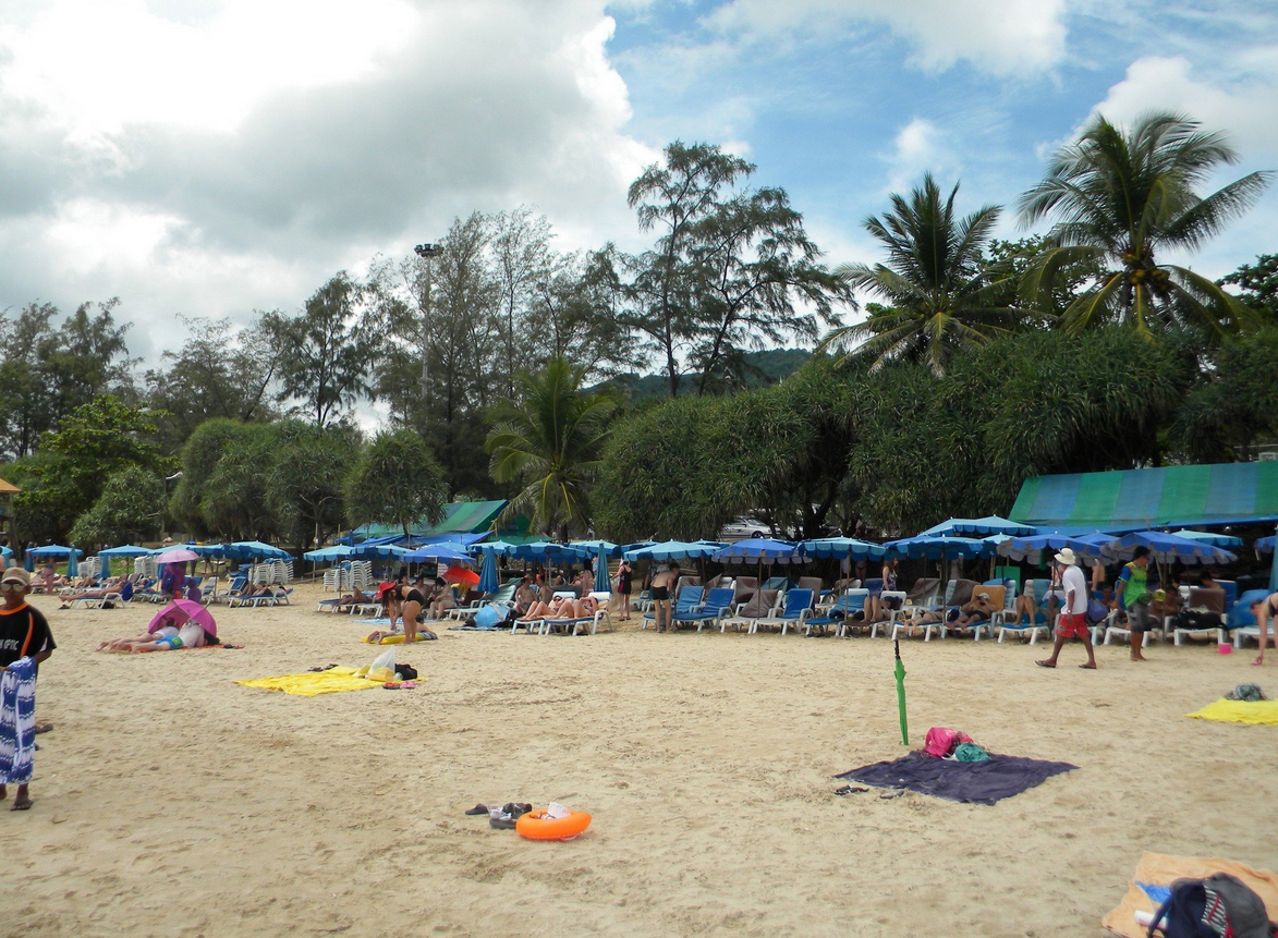 На пляже установлены лежаки и зонтики